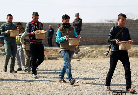 Sunni Arab fighters carries pots that are being made into improvised explosive devices (IEDs) to demolish homes belonging to Islamic States militants, in Rfaila village in the south of Mosul, Iraq, February 17, 2017. REUTERS/Khalid al Mousily