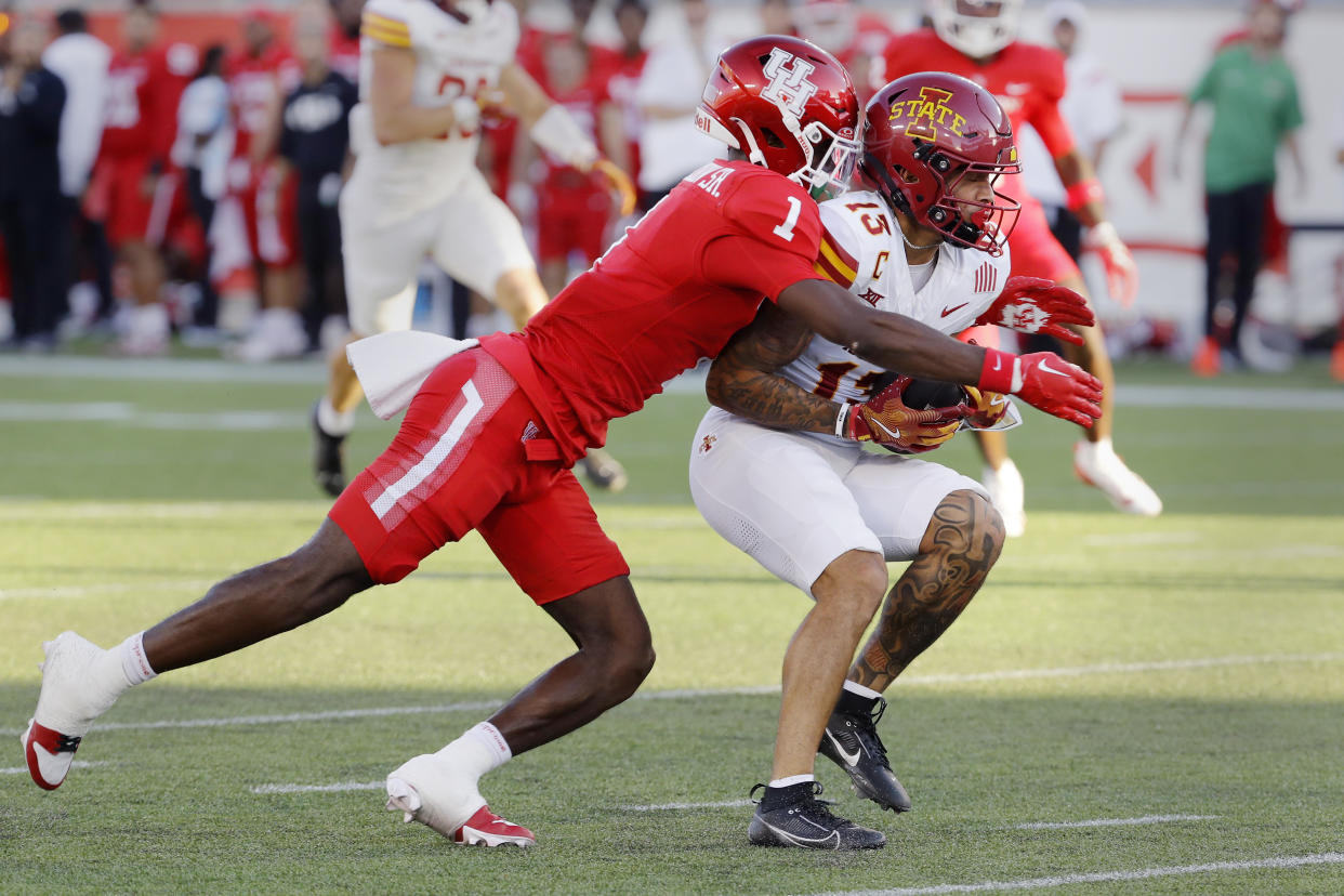 Iowa State wide receiver Jaylin Noel (13) is tackled by Houston defensive back Latrell McCutchin Sr. (1) during the first half of an NCAA college football game, Saturday, Sept. 28, 2024, in Houston. (AP Photo/Michael Wyke)