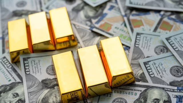 Gold bars on top of $100 bills.