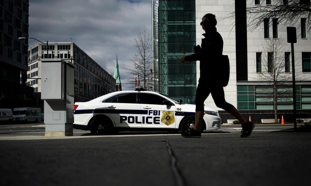 <span>A woman walks past an FBI vehicle in March 2019 in Washington DC.</span><span>Photograph: Brendan Smialowski/AFP/Getty Images</span>