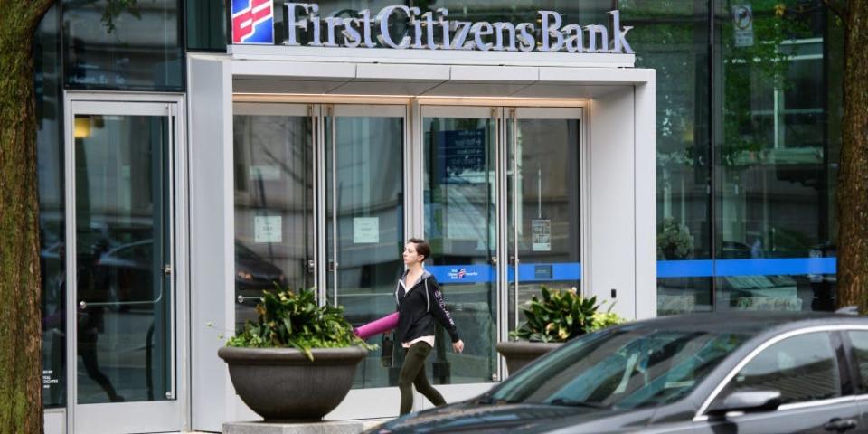 A woman walks in front of a First Citizens Bank branch in Raleigh, North Carolina.