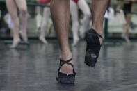 In this photo taken Nov. 25, 2012, Filipino slum dweller Jamil Montebon uses his worn-out ballet shoes as he practices steps during a class at Ballet Manila in the Philippine capital. Montebon, a scholar at Ballet Manila's program, used to collect garbage and also worked at a junk shop. He now receives a monthly stipend, stays at their dormitory and is given meals. (AP Photo/Aaron Favila)