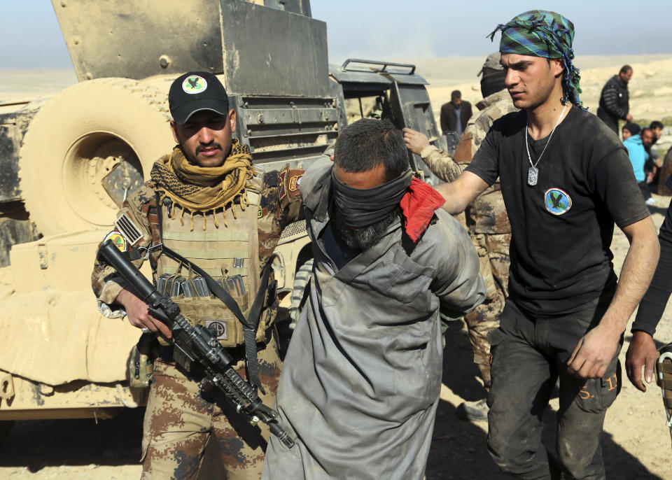 FILE - In this Feb. 25. 2017 file photo, Iraqi special forces arrest a fighter with Islamic State militia in Mosul, Iraq. The Islamic State group erupted from the chaos of Syria and Iraq's conflicts and swiftly did what no Islamic militant group had done before, conquering a giant stretch of territory and declaring itself a "caliphate." U.S. officials said late Saturday that their shadowy leader Abu Bakr al-Baghdadi was the target of an American raid in Syria and may have died in an explosion. (AP Photo/Khalid Mohammed, File)