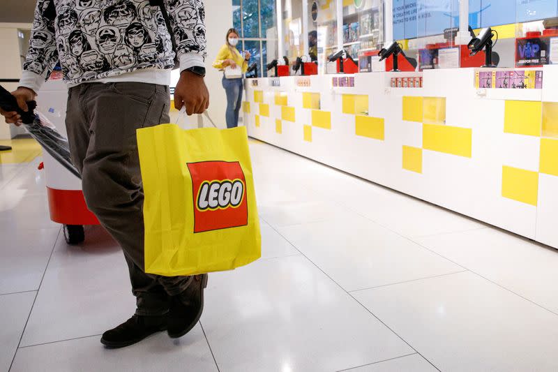 FILE PHOTO: A customer carries a bag while shopping in the 5th Avenue Lego store in New York