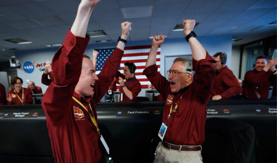 Nasa engineers Kris Bruvold, left, and Sandy Krasner celebrate the successful touchdown by the InSight spacecraft from the Mission Support area at the Nasa Jet Propulsion Laboratory in California (Picture: Getty)