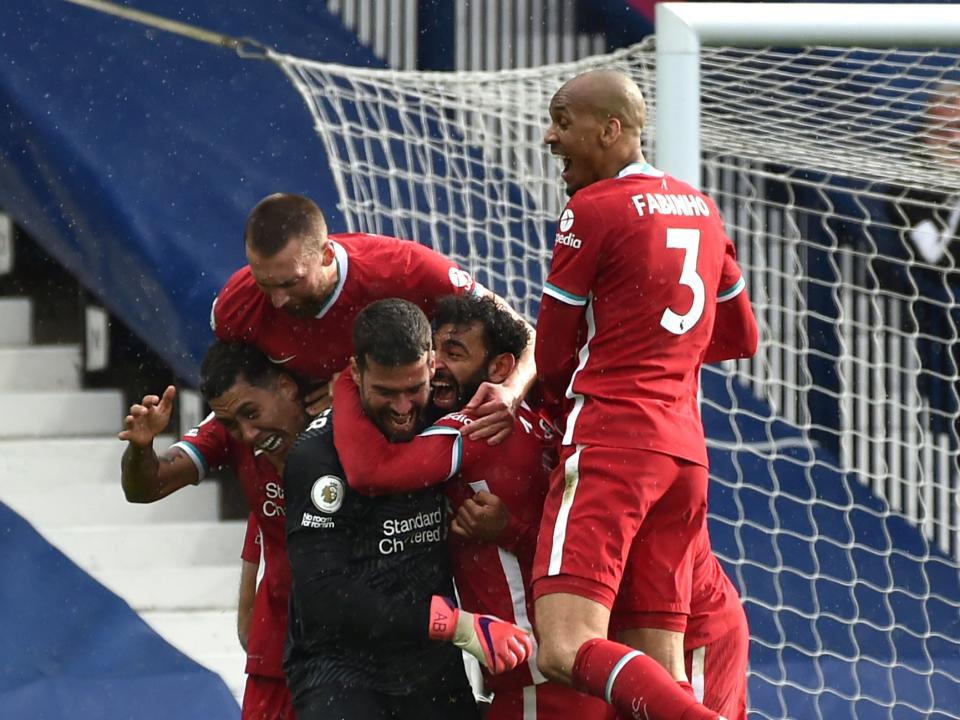 Liverpool players celebrate with Alisson after the goalkeeper’s late winner against West Brom (Getty Images)