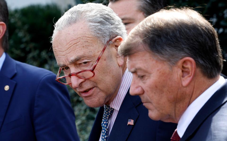 two men in suits speak on the white house lawn