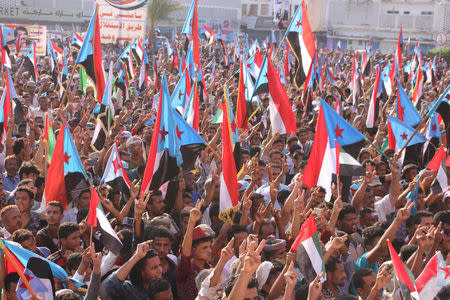 People hold up the flag of former South Yemen during a rally commemorating the 53nd anniversary of the start of South Yemen's uprising against British rule, in the southern port city of Aden, Yemen October 14, 2016. Picture taken October 14, 2016. REUTERS/Fawaz Salman