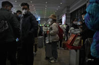 Travelers prepare to catch their trains at the West Railway Station in Beijing, Sunday, Jan. 15, 2023. The World Health Organization has appealed to China to keep releasing information about its wave of COVID-19 infections after the government announced nearly 60,000 deaths since early December following weeks of complaints it was failing to tell the world what was happening. (AP Photo/Andy Wong)