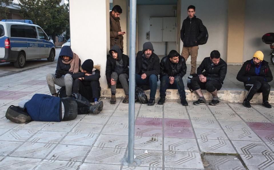 Migrants from Syria and Iraq wanting to register for asylum, sit on a pavement in Orestiada town, northeastern Greece, Monday, April 22, 2019. Greek authorities say dozens of asylum-seekers have turned up at the front door of European border agency employees helping police Greece's northeastern border with Turkey. (AP Photo/Antonis Pasvantis)