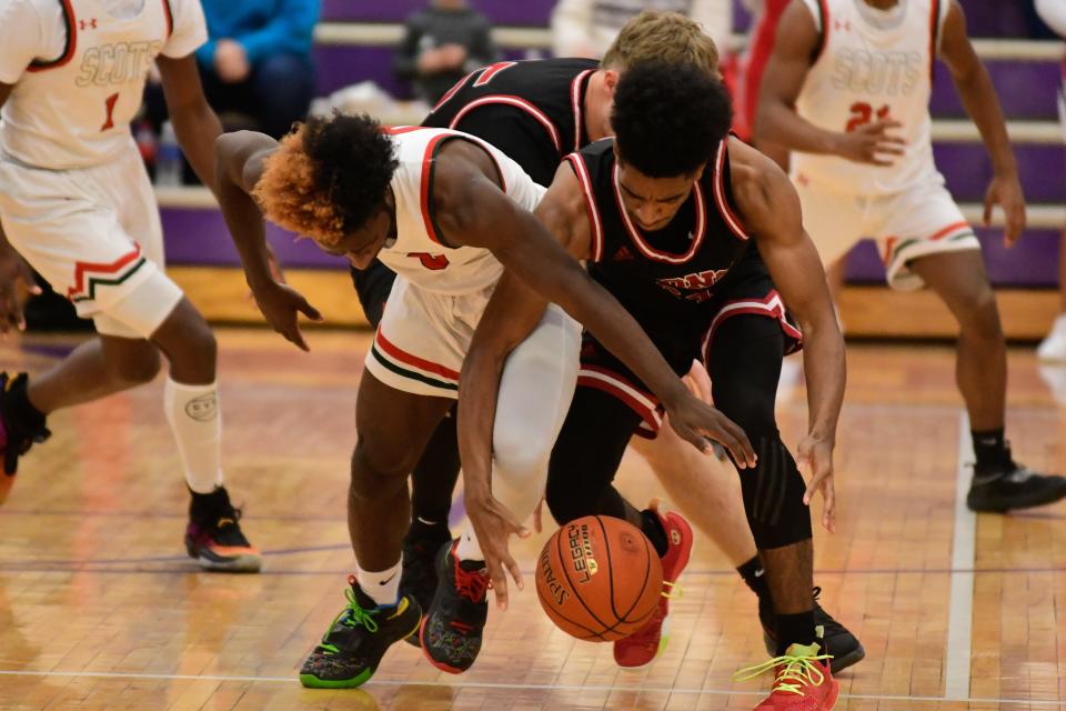 Highland Park senior Tre Richardson (1) fights for possession of the ball from Lawrence junior Zaxton King (24) in the first half of the championship game at the Topeka Invitational Tournament.