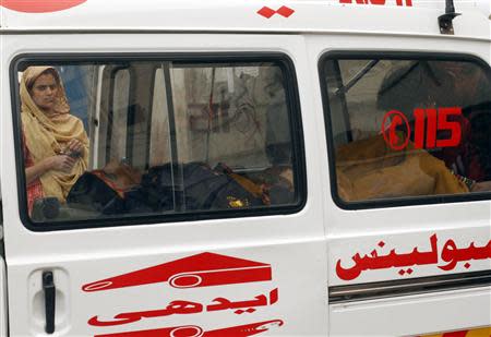 A woman, who was injured by unidentified gunmen, lies in an ambulance after being brought to the Civil Hospital for treatment in Karachi March 12, 2014. REUTERS/Athar Hussain