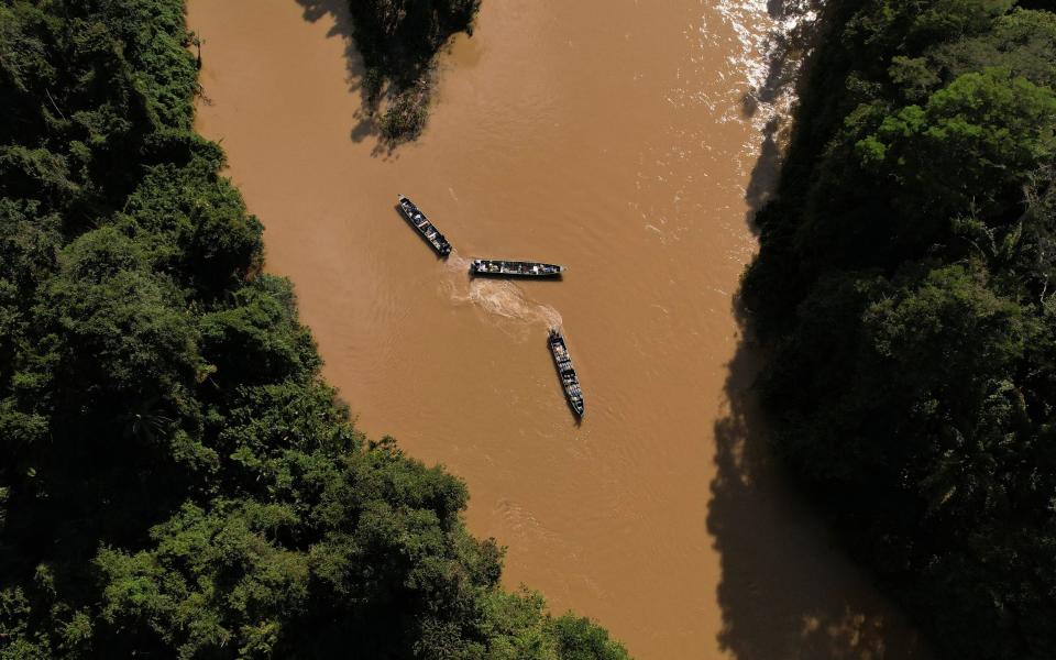 Boats loaded with miners and mining supplies, such as fuel barrels, in the Uraricoera river - AMANDA PEROBELLI/Reuters