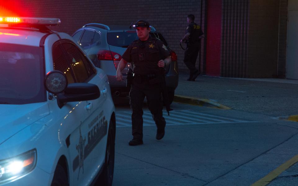 A Vanderburgh County Sheriff's Office deputy armed with a semi-automatic rifle walks back toward his squad car from the Eastland Mall's JCPenney on Saturday, May 13, 2023. A large fight reportedly broke out and led to fears of a potential active shooter, triggering an intense law enforcement response.