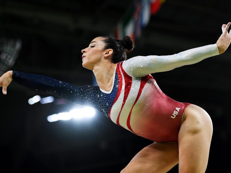 Aly Raisman competing in gymnastics wearing a Team USA leotard.