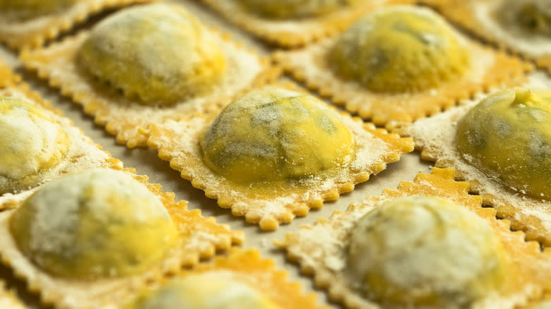 uncooked ravioli on cutting board