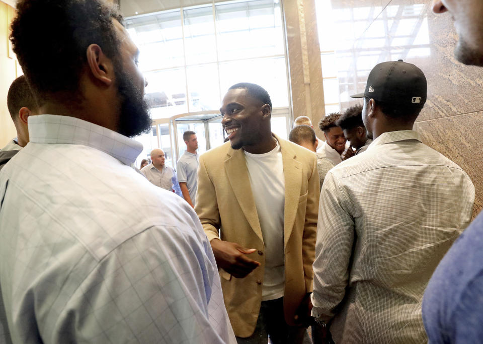 Former Wisconsin Badger football player Quintez Cephus, center, greets current members of the team following a press conference to reiterated his request for reinstatement to the university in Madison, Wis. Monday, Aug. 12, 2019. The former wide receiver was acquitted earlier this month of sexual assault charges stemming from a campus incident in his apartment. He was expelled from the university in March after the university's own internal investigation. (John Hart/Wisconsin State Journal via AP)