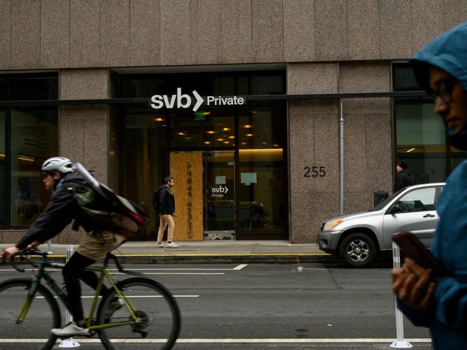  Pedestrians and a cyclist pass by the Silicon Valley Bank branch office in downtown San Francisco, on March 13.