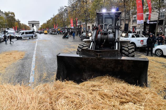 PARIS, FRANCE - NOVEMBER 27: A backhoe clears the straws covering the ground during a protest by farmers titled 