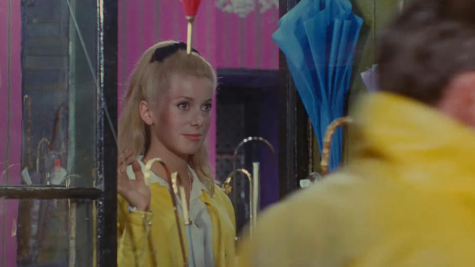 Catherine Deneuve stands in an umbrella shop in The Umbrellas of Cherbourg