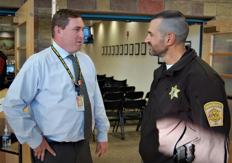 San Juan County Manager Mike Stark, left, chats with Capt. Mark Pfetzer Feb. 16 at the County Administration Building during a celebration for Pfetzer's Team Guardian.