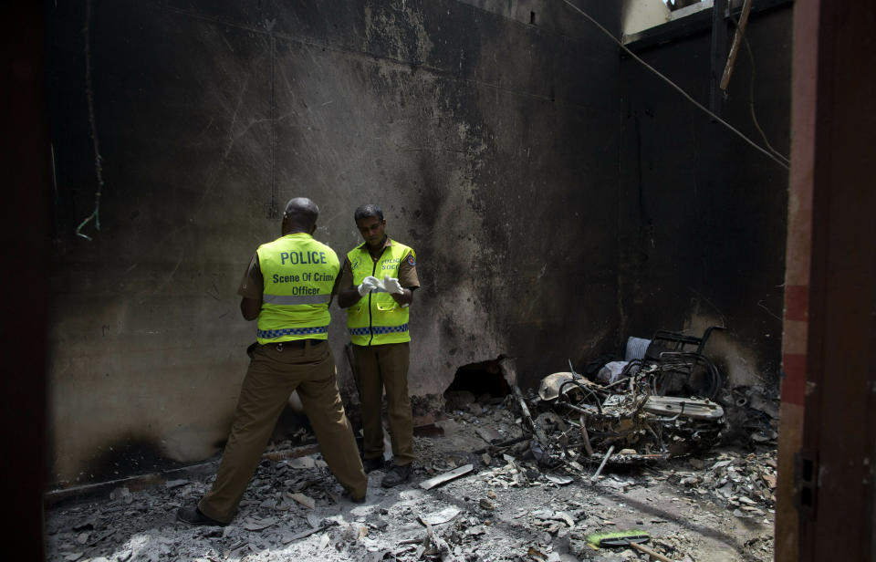 Police officers collect evidence from a site of a gun battle between troops and suspected Islamist militants in Kalmunai, Sri Lanka, Sunday, April 28, 2019. Police in Ampara showed The Associated Press on Sunday the explosives, chemicals and Islamic State flag they recovered from the site of one security force raid in the region as Sri Lanka's Catholics celebrated at televised Mass in the safety of their homes. (AP Photo/Gemunu Amarasinghe)