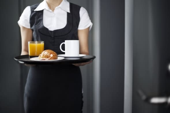 Room service hotel staff carries breakfast tray