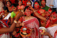 <p>A woman reacts as “Sindur”, or vermillion powder, is applied to her face after worshipping an idol of the Hindu goddess Durga on the last day of the Durga Puja festival in Chandigarh, India, Sept. 30, 2017. (Photo: Ajay Verma/Reuters) </p>