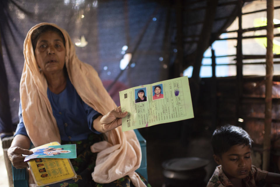 Momina Begum shows photos of her son, Muhammed Ibrahim, and daughter-in-law, Kurshida Begum, during an interview at the Nayapara refugee camp in Teknaf, part of the Cox's Bazar district of Bangladesh, on March 8, 2023. The couple and Momina's grandchildren, aged 3 and 4, were aboard a crowded boat that sank in the sea south of Bangladesh on Dec. 7, 2022. When news of them boarding the boat reached her, she screamed, “Where are you going with these children? ... Why are you crossing the dangerous sea with these children?” (AP Photo/Mahmud Hossain Opu)