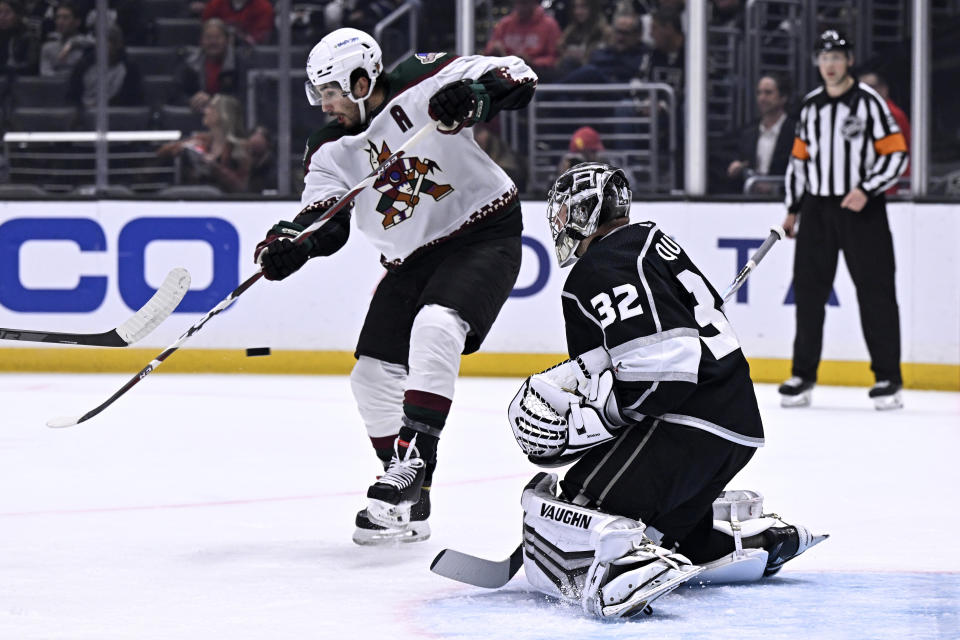 Arizona Coyotes center Nick Schmaltz, left, redirects a shot toward Los Angeles Kings goaltender Jonathan Quick during the first period of an NHL hockey game in Los Angeles, Thursday, Dec. 1, 2022. (AP Photo/Alex Gallardo)