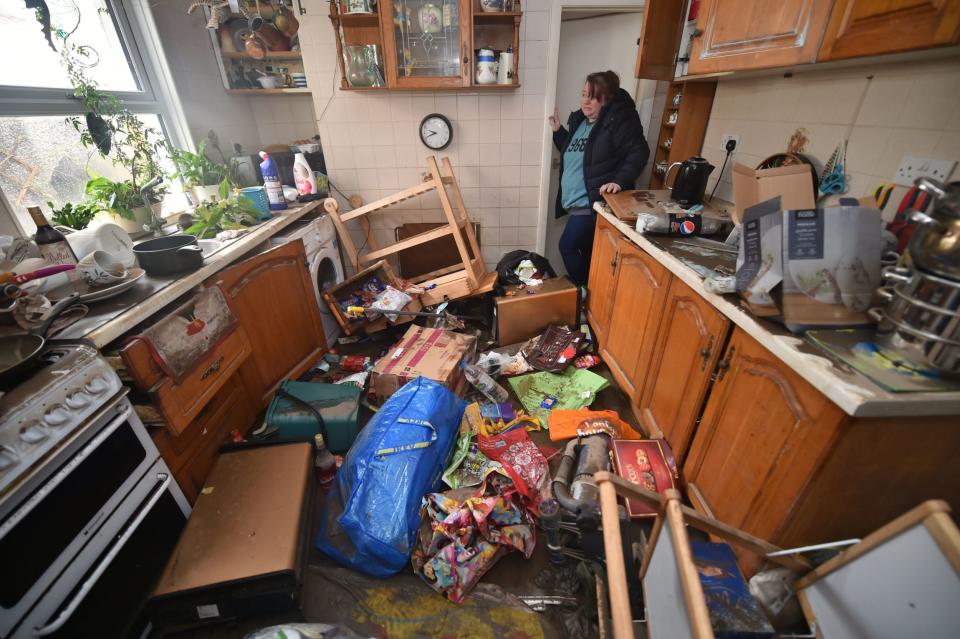 Rachel Cox inspecting flood damage in her kitchen in south Wales: PA