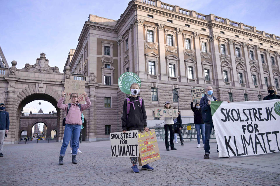 Swedish climate activist Greta Thunberg, center, holding a sign reading "School strike for Climate"and others protest in front of the Swedish Parliament Riksdagen in Stockholm Friday, Sept. 25, 2020. ( Janerik Henriksson/TT News Agency via AP)