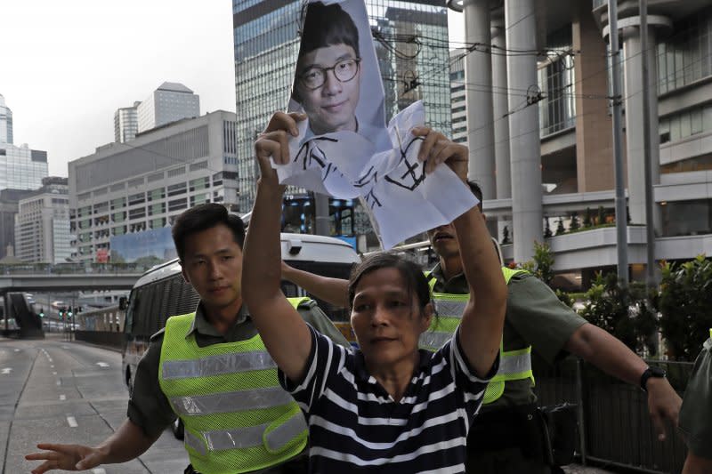 香港青年世代政治領袖黃之鋒、羅冠聰、周永康遭判刑入獄，支持者激動抗議（AP）