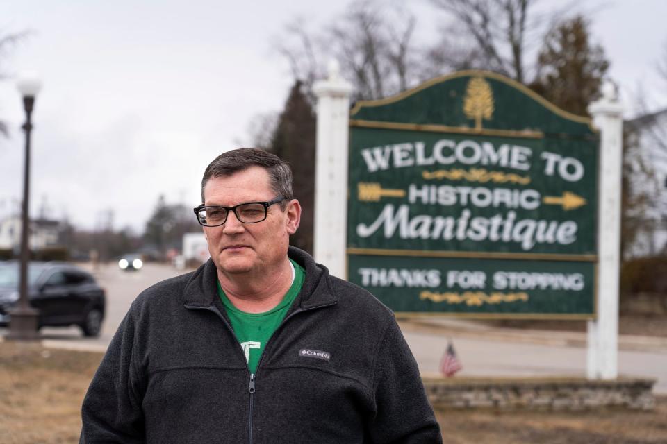 Schoolcraft County Board of Commissioners chairman Paul Walker stands by a sign leading into downtown Manistique on Tuesday, March 26, 2024.