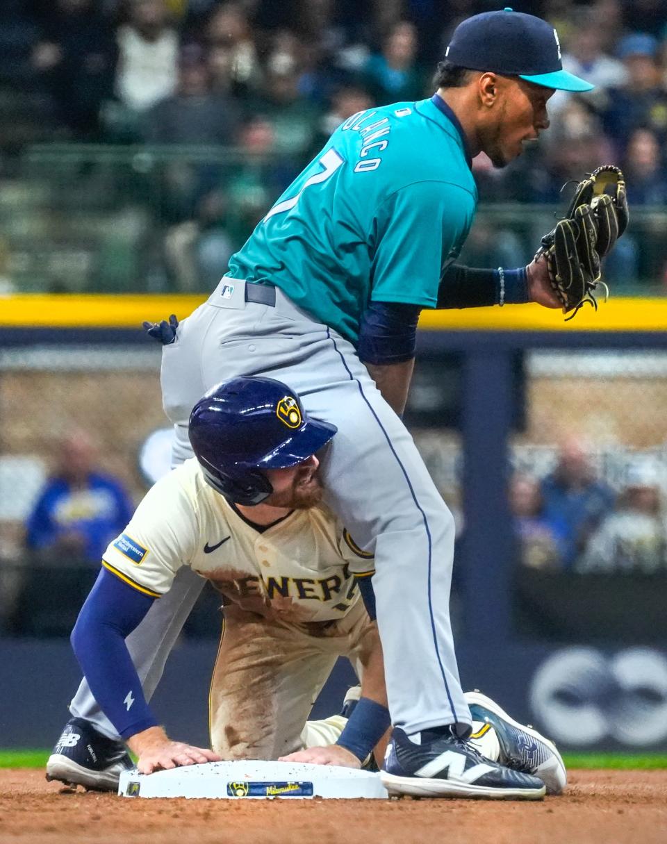 Milwaukee Brewers third baseman Oliver Dunn (15) slides into second base safe over Seattle Mariners second baseman Jorge Polanco (7) during the bottom of the first inning of their game Sunday, April 7, 2024, at American Family Field in Milwaukee.