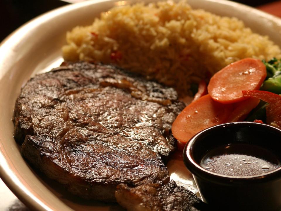 plate of prime rib with rice and vegetables from outback steakhouse