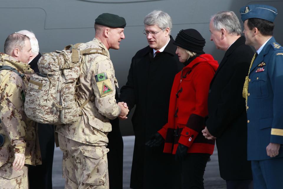Canadian Army Major General Dean Milner shakes hands with Canada's Prime Minister Stephen Harper after arriving from Afghanistan, in Ottawa
