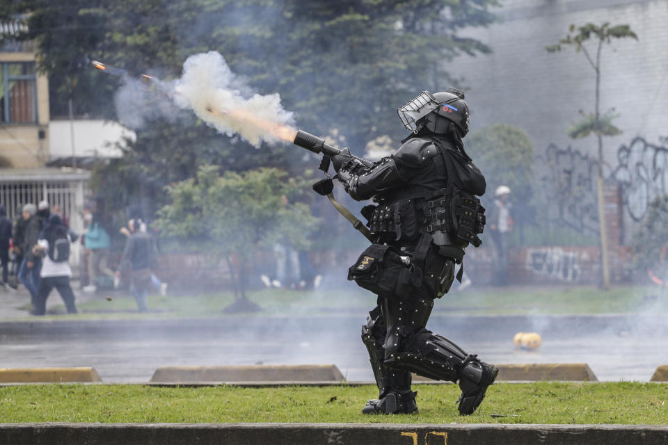 Un policía dispara gases lacrimógenos a manifestantes en Bogotá, Colombia, el jueves 21 de noviembre de 2019. (AP Foto / Ivan Valencia)