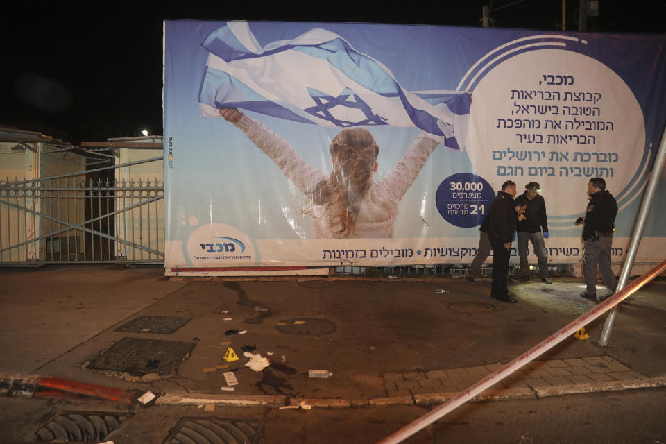 Israeli police officers inspect the scene of an attack in Jerusalem, early Thursday, Feb. 6, 2020. A Palestinian motorist slammed his car into a group of soldiers early on Thursday, wounding more than a dozen before fleeing the scene, Israeli police said. (AP Photo/Mahmoud Illean)