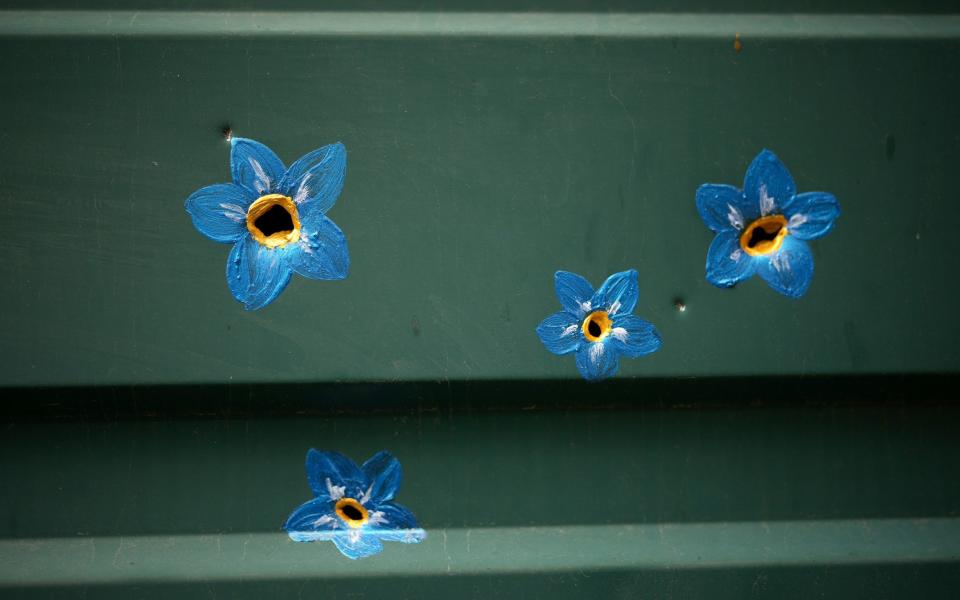 Forget-me-not flowers painted around bullet and shrapnel holes - Christopher Furlong /Getty Images Europe 