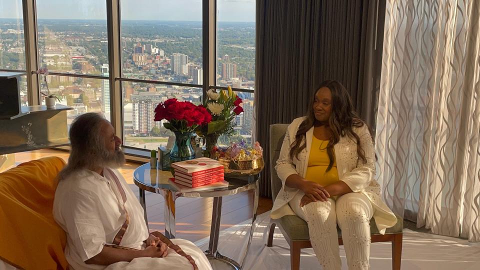 LaTrece Cash, of Detroit, speaks with Gurudev Sri Sri Ravi Shankar at the Detroit Marriott at Renaissance Center on Aug. 22, 2023.