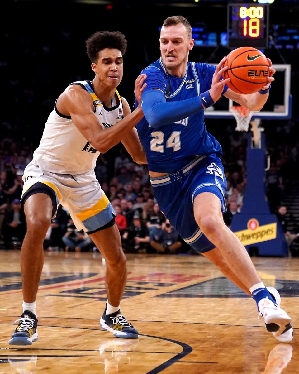 Xavier Musketeers forward Jack Nunge (24) drives to the basket as Marquette Golden Eagles forward Oso Ighodaro (13) defends in the first half of an NCAA college basketball game during the championship round of the Big East Conference tournament, Saturday, March 11, 2023, at Madison Square Garden in New York. 