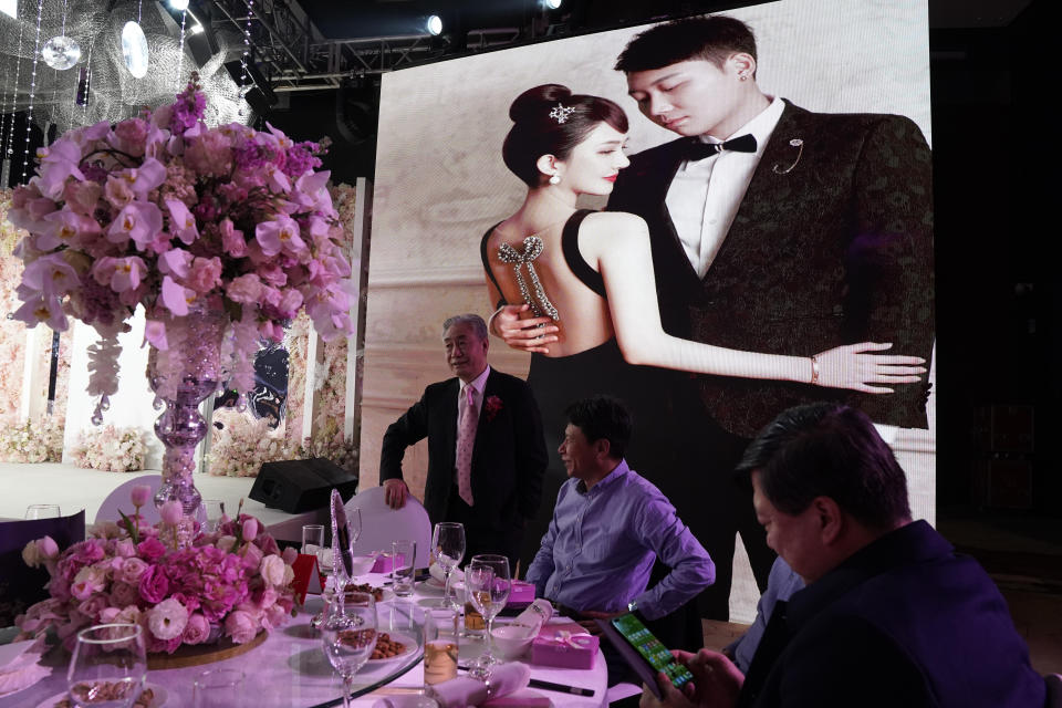 Family and guests attend the wedding banquet for Chen Yaxuan and Dou Di in Beijing on Saturday, Dec. 12, 2020. Lovebirds in China are embracing a sense of normalcy as the COVID pandemic appears to be under control in the country where it was first detected. (AP Photo/Ng Han Guan)