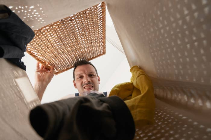 man looking into laundry hamper