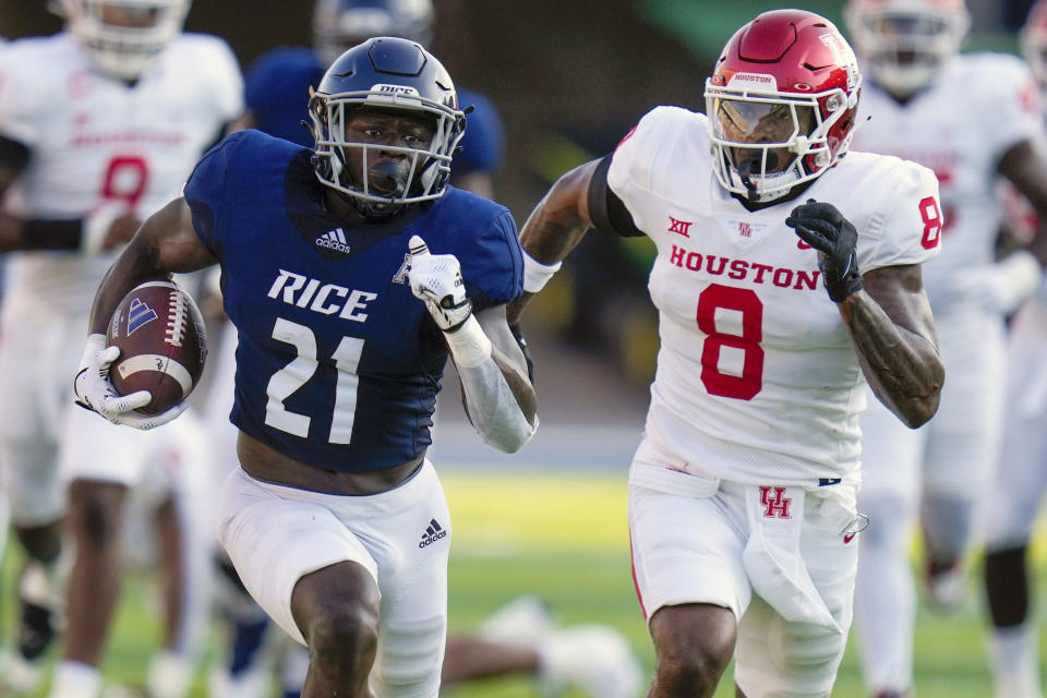 Rice running back Juma Otoviano (21) rushes past Houston linebacker Malik Robinson (8) during the first half of an NCAA college football game, Saturday, Sept. 9, 2023, in Houston. (AP Photo/Eric Christian Smith)