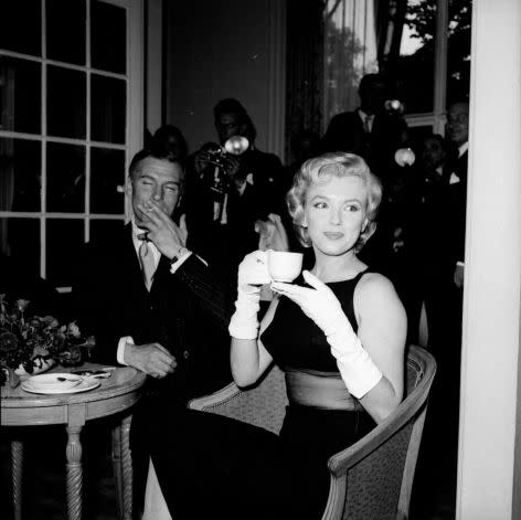 In 1956, drinking tea with Sir Laurence Olivier