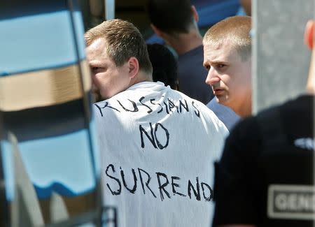 Russian soccer fans suspected of being involved in clashes, one wearing a banner saying "Russians No Surrender", are ushered off their bus after being stopped by gendarmes in Mandelieu near Cannes in southern France, June 14, 2016. REUTERS/Eric Gaillard