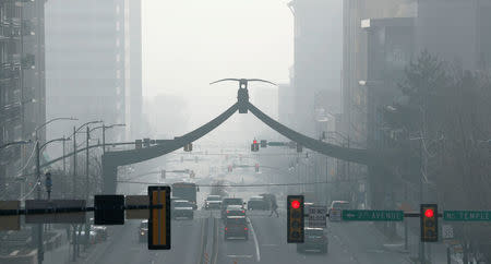 FILE PHOTO: Cars and people move up and down State Street in smog filled downtown Salt Lake City, Utah, U.S. December 12, 2017. REUTERS/George Frey