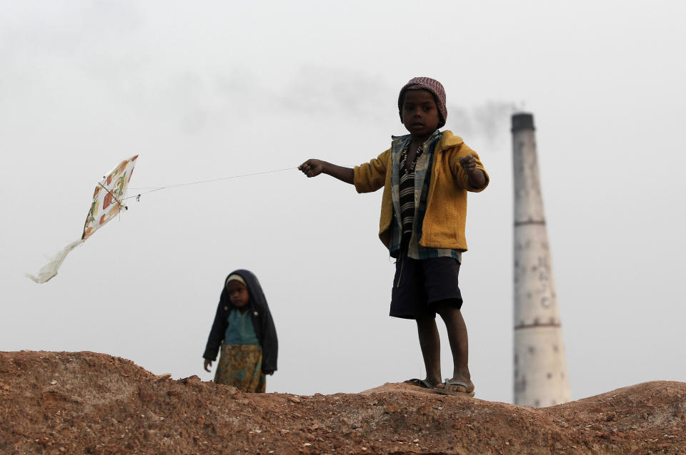 A boy flies a kite near a brick factory on the outskirts of the eastern Indian city of Patna.