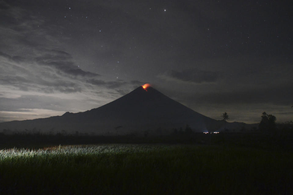 Mount Semeru releases volcanic materials during an eruption as seen from Lumajang district, East Java province, Indonesia, Tuesday, Dec. 7, 2021. The highest volcano on Java island spewed thick columns of ash into the sky in a sudden eruption Saturday triggered by heavy rains. Villages and nearby towns were blanketed by tons of volcanic debris. (AP Photo/Hendra Permana)